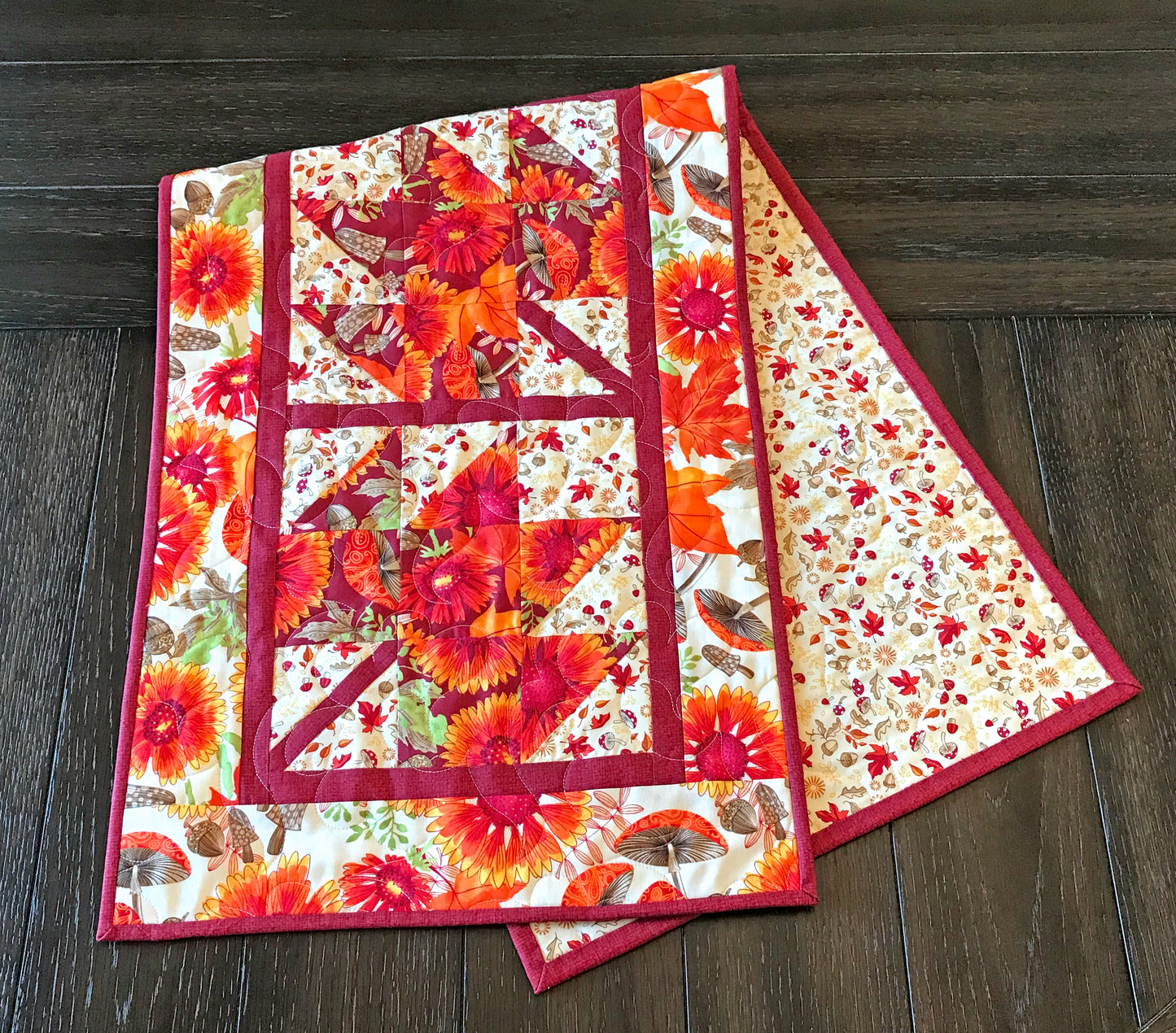 Close up of Fall Leaves table runner pattern featuring 4 maple leaf blocks surrounded by sashing and a matching border.