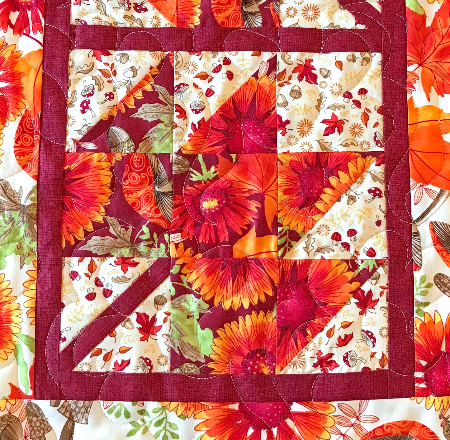 Close up of Fall Leaves table runner pattern featuring 4 maple leaf blocks surrounded by sashing and a matching border.