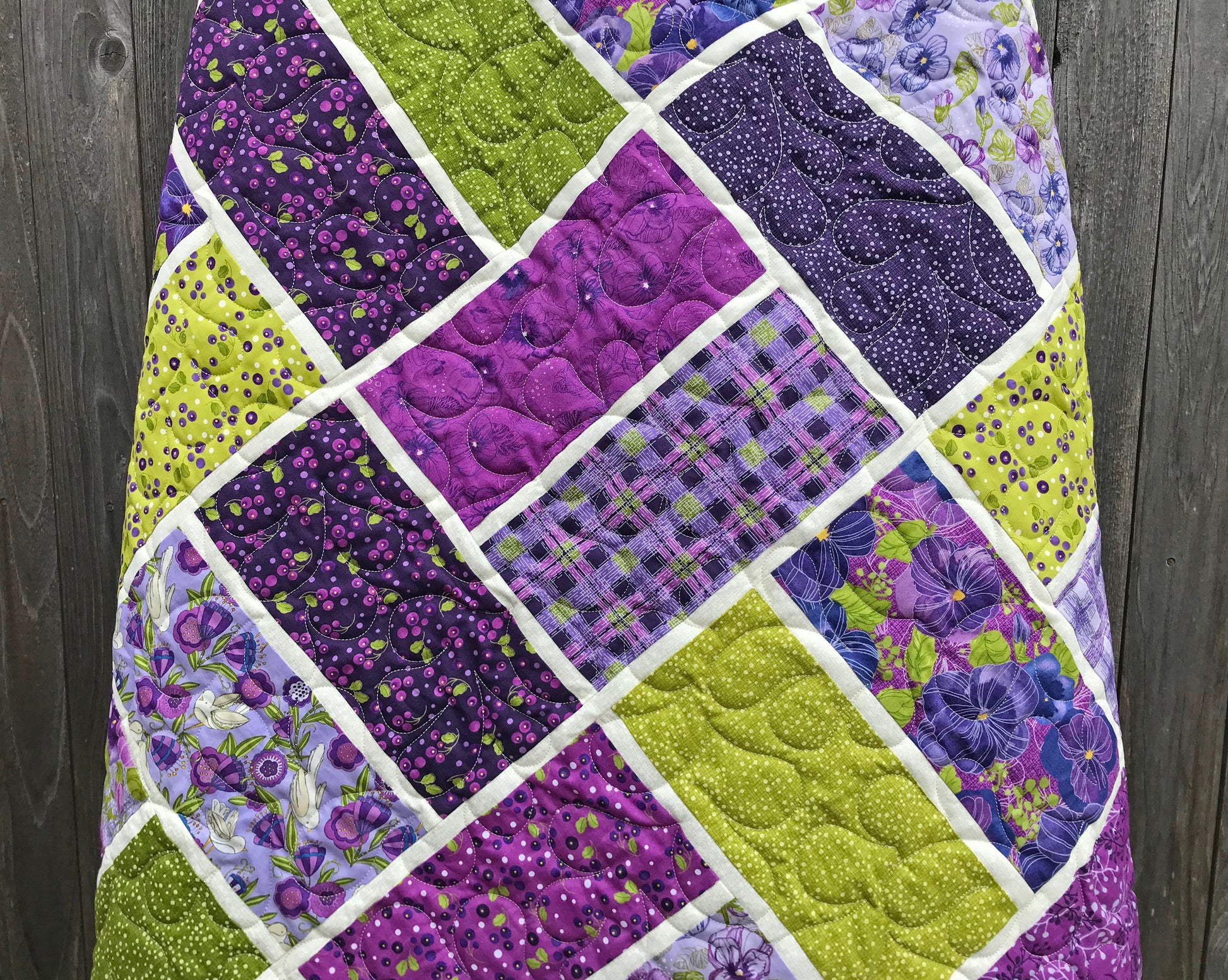 close up of purple and green large block quilt made from Bricktown quilt pattern