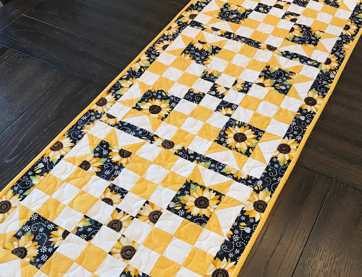 table runner displayed on a table for pattern for a table runner or table topper that has sawtooth star corner units with nine patch blocks in between.