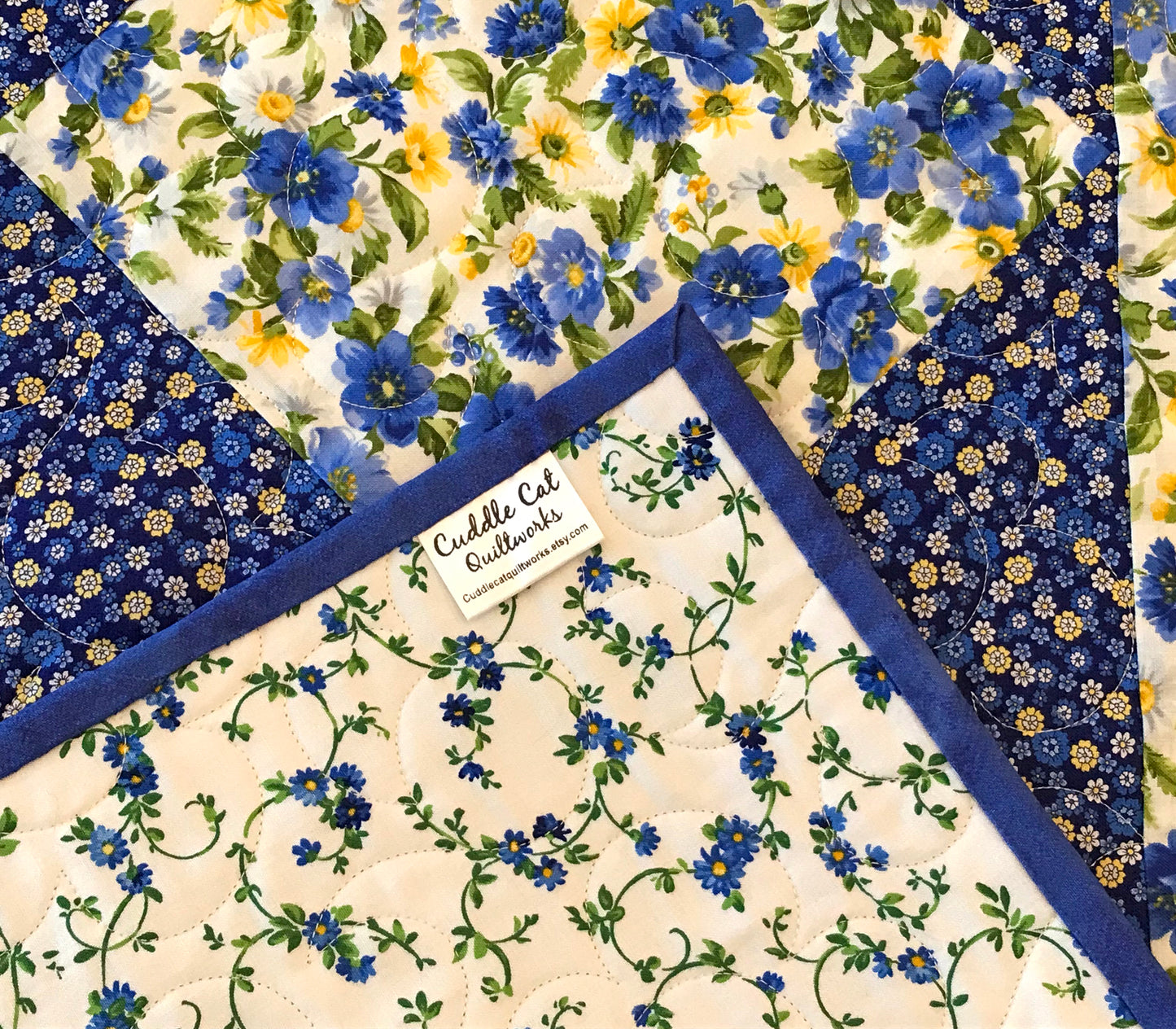 close up of corner label on Blue and yellow floral table runner with a center diamond pattern displayed on a table