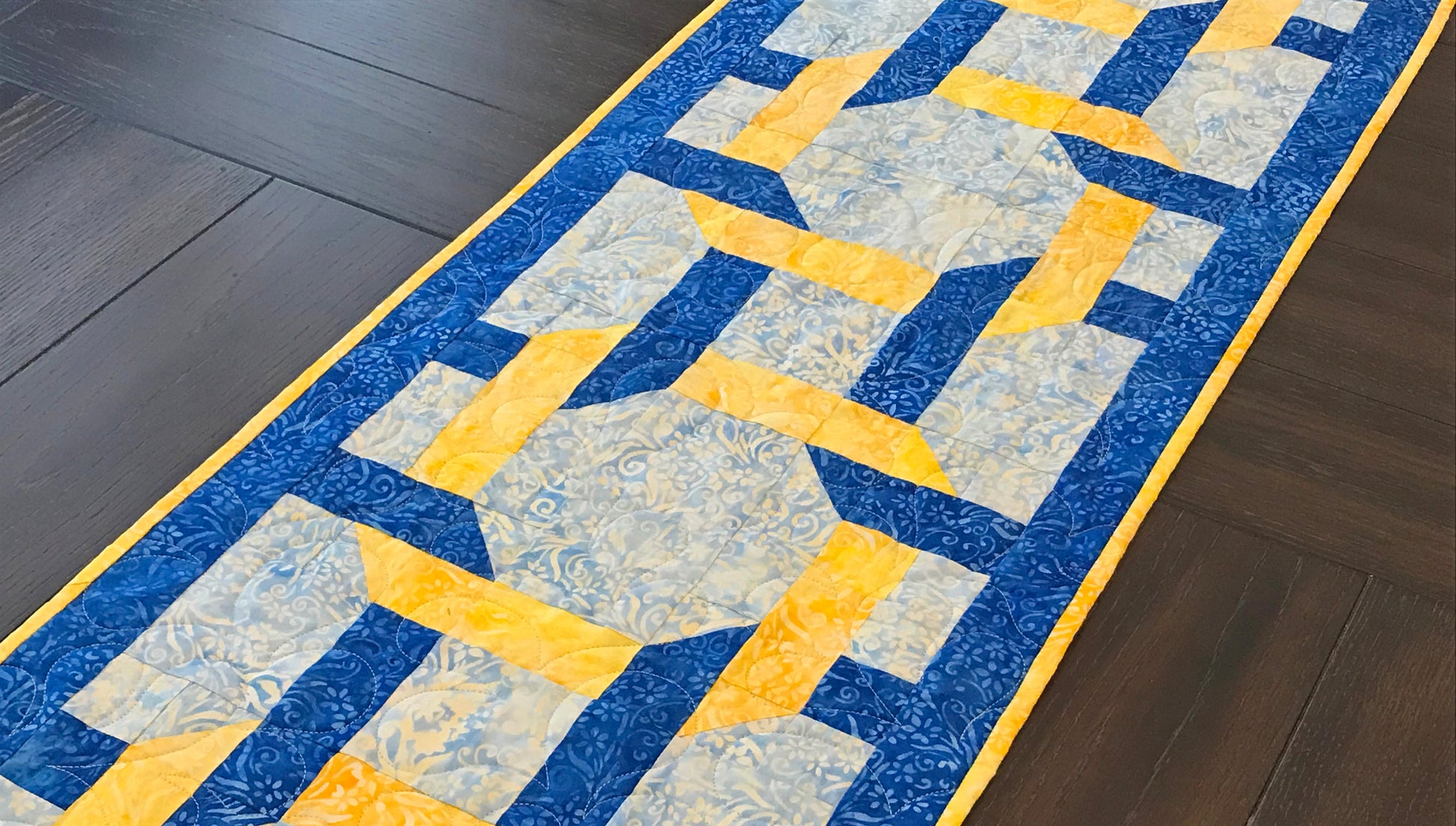 Pattern for blue and yellow table runner with woven corners through three large squares. Woven Squares pattern.