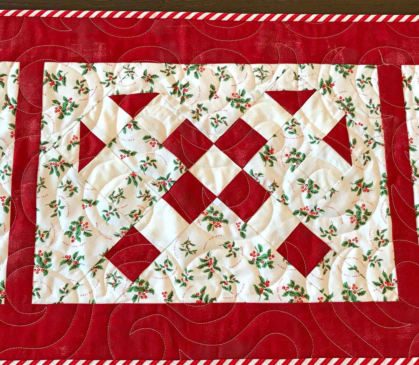 Digital pattern for a quilted Christmas table runner that has candy canes in three sections surrounded by a border.