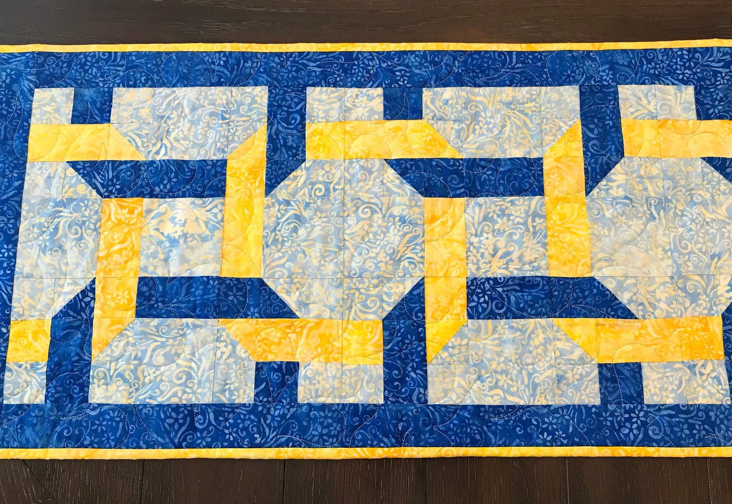 Pattern for blue and yellow table runner with woven corners through three large squares. Woven Squares pattern.