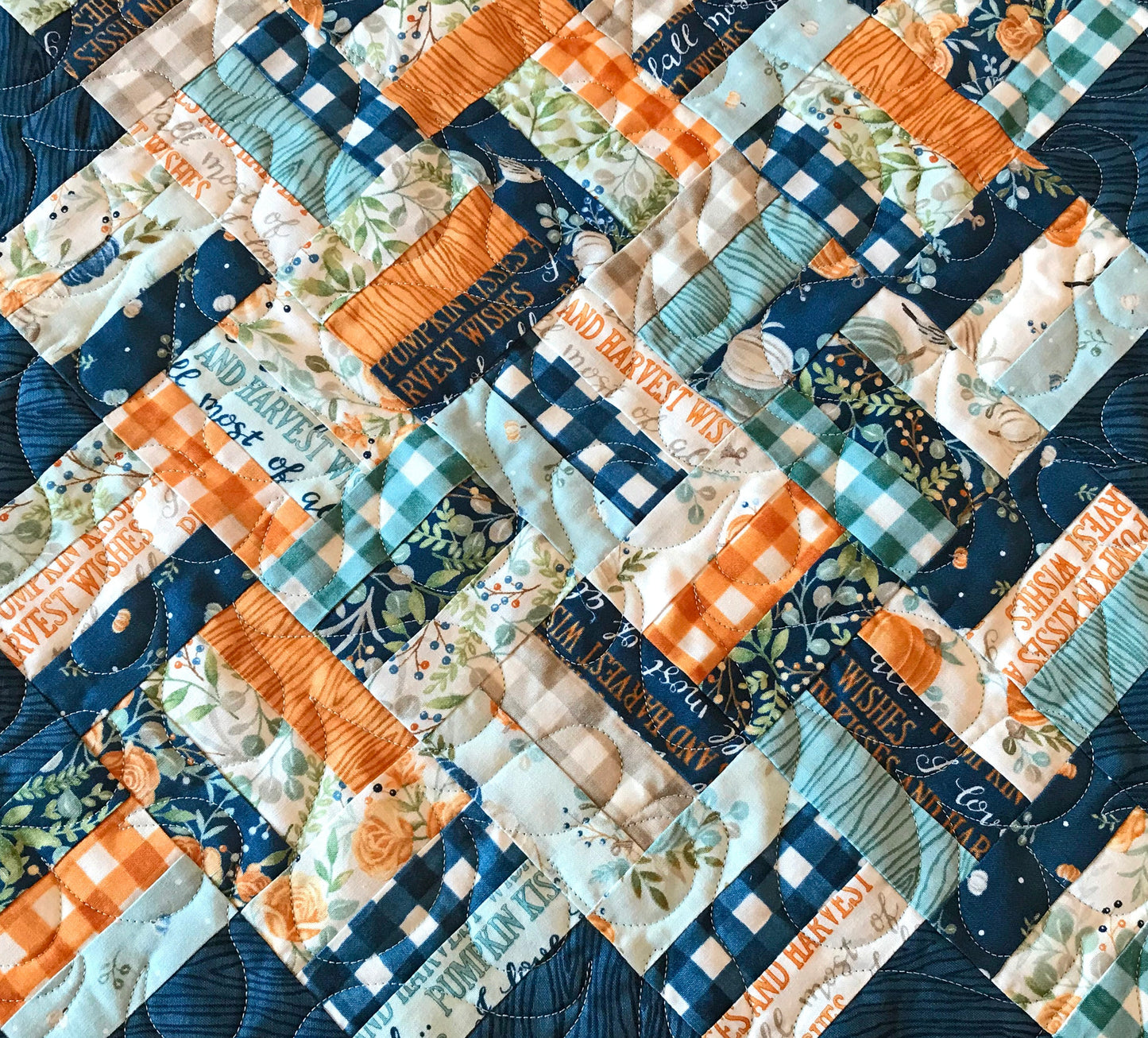 Braided Squares table runner and topper pattern. Sample runner and topper shown with a fall color scheme of dark blue, aqua, cream and orange. Close up of braided squares.